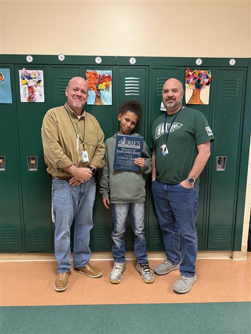 Damaria Granberry, Harding's Stairclimber recipient for January, poses with her plaque and school staff members.